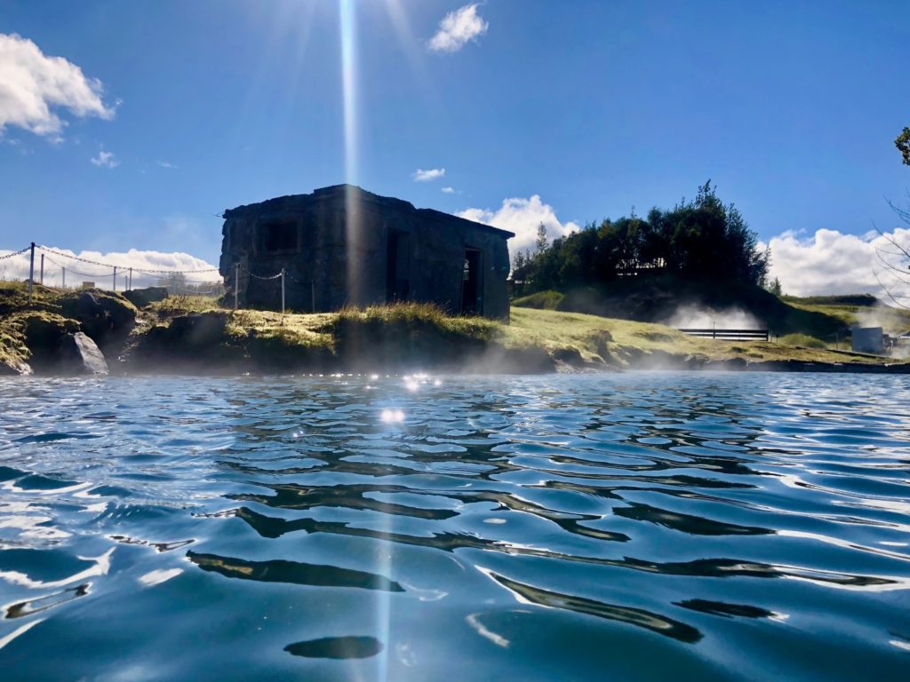 secret lagoon in iceland on a sunny day with blue sky