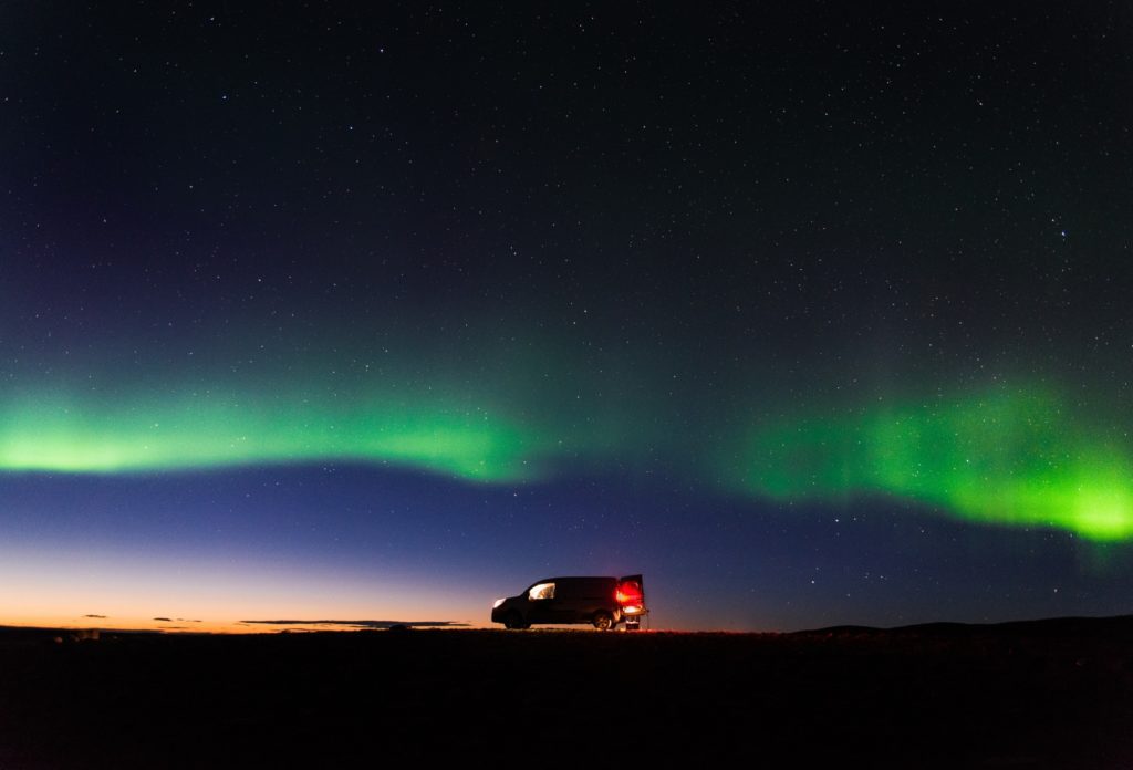 The northern lights above a camper van after sunset in Iceland