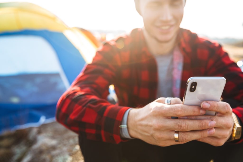 Man using phone during camping Iceland