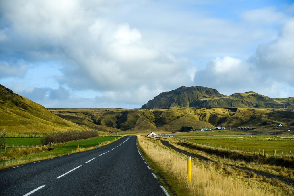 The Ring Road pass through mountain and field landscape in summer of Iceland