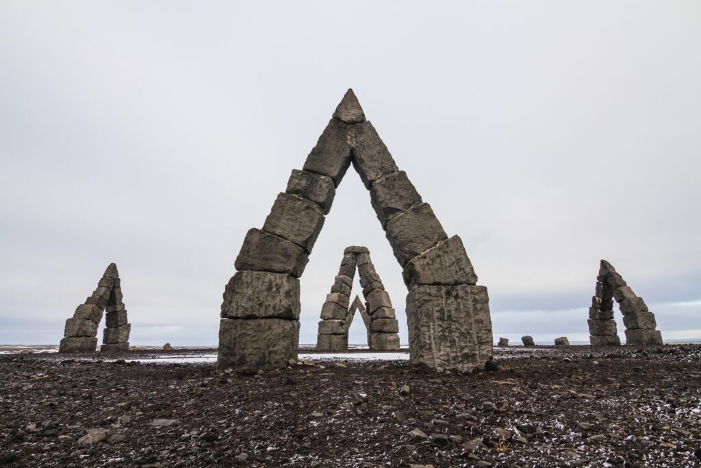 Arctic Henge surrounded by a field covered in the snow under a cloudy sky in Iceland