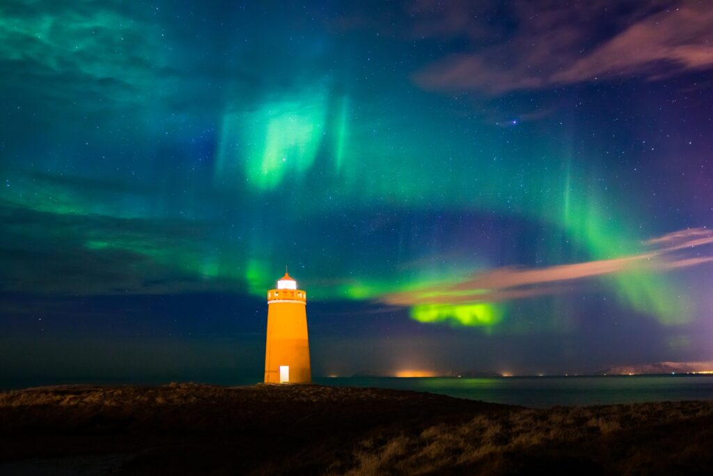 Lighthouse on Reykjanes peninsula under nortern lights. Iceland.