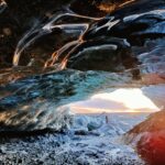 Ice cave of the Katla volcano with the sunset in the background in Iceland