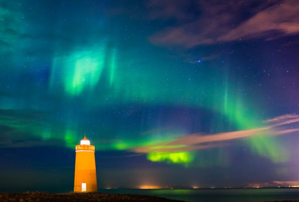 Lighthouse on Reykjanes peninsula under nortern lights. Iceland.